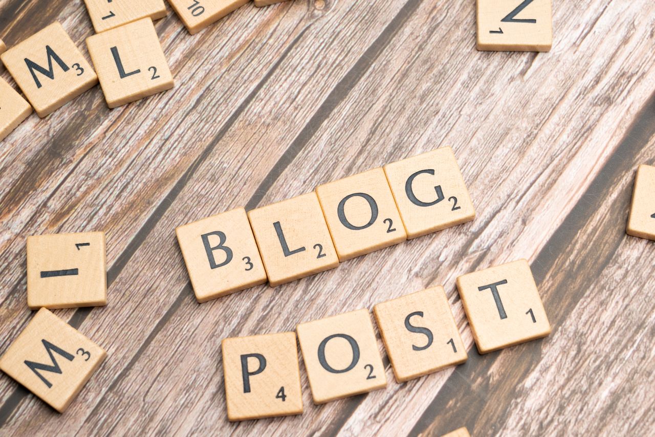 Wooden letter tiles spelling Blog Post on a wooden background, ideal for online media concepts.